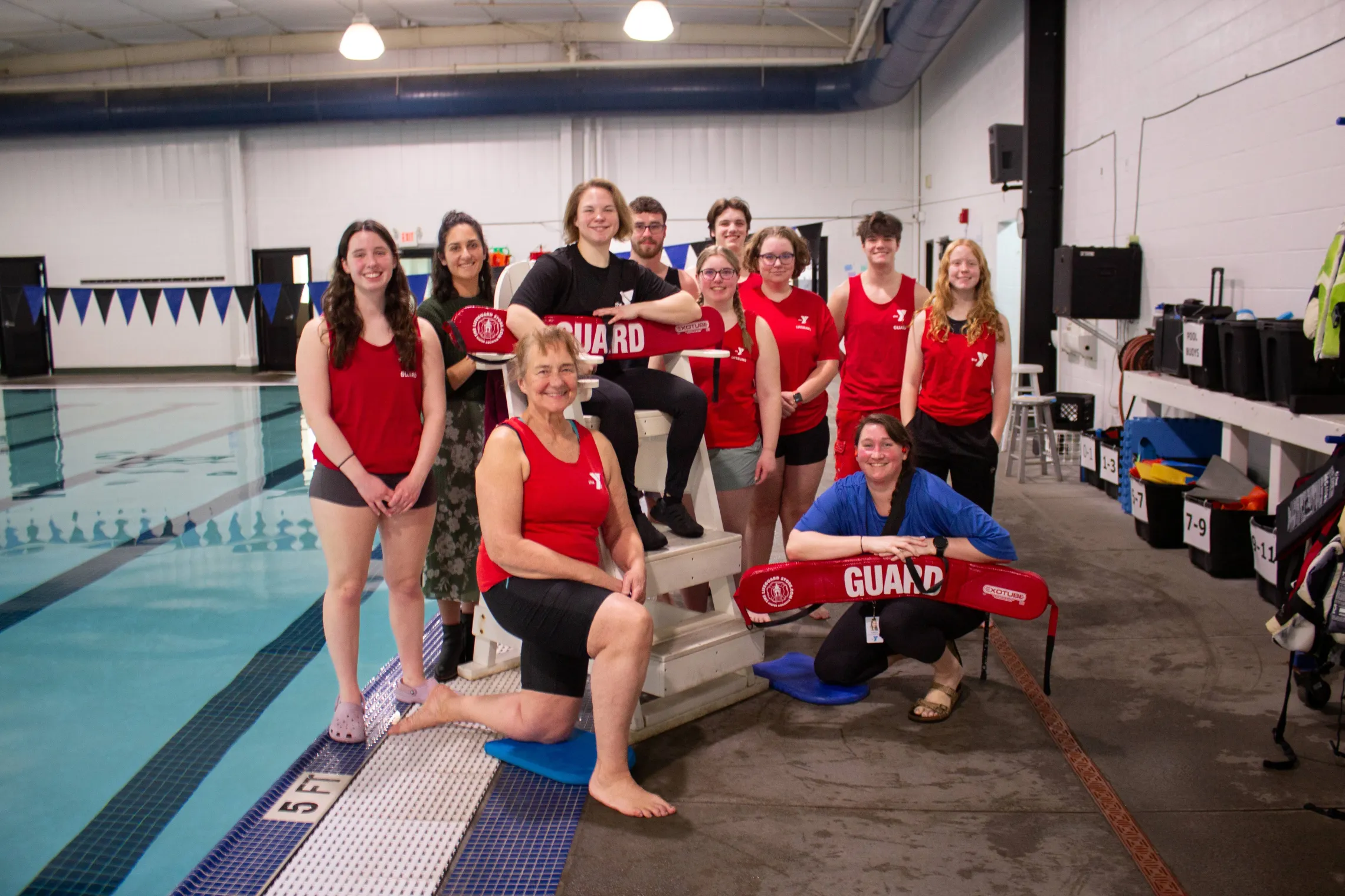 Lifeguards pose for a photo next to a pool