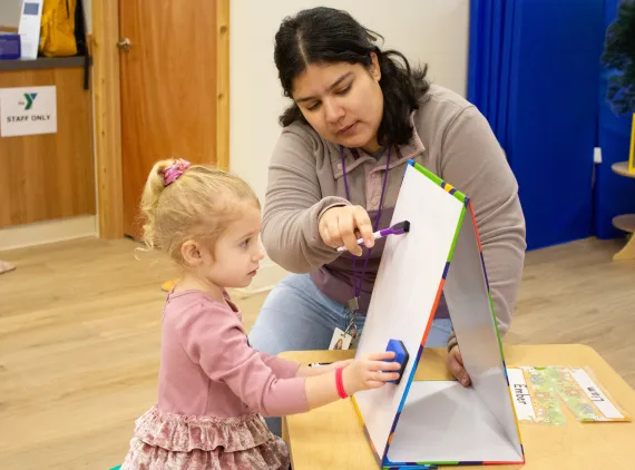 A woman and child using a whiteboard