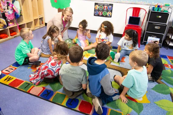 A teacher showing numerous kids a hamster ball