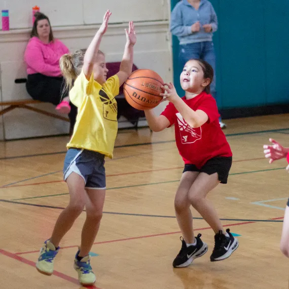Two girls playing basketball